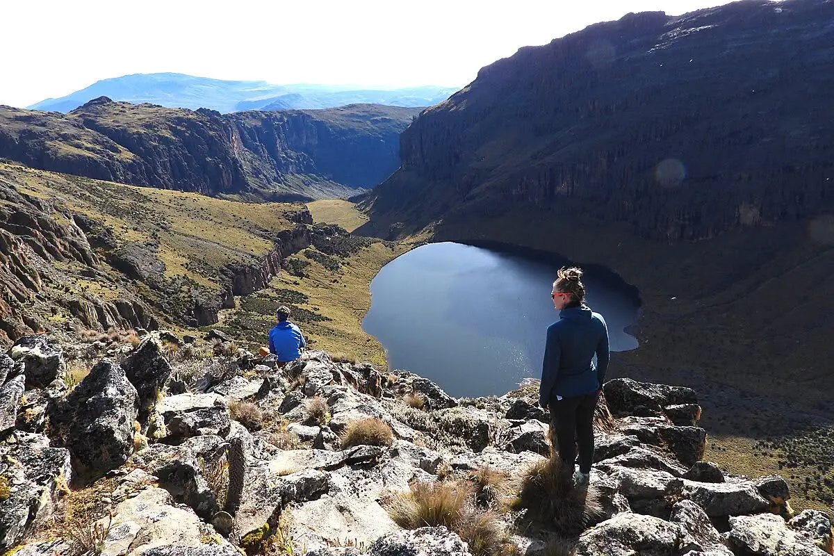 Hikers overlooking an alpine lake on Mount Kenya