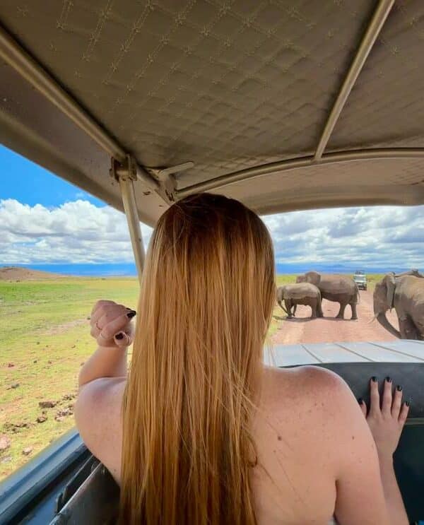 Guest on a private safari game drive in Amboseli National Park during a 3 Day Amboseli Safari, observing wildlife from an open safari vehicle.