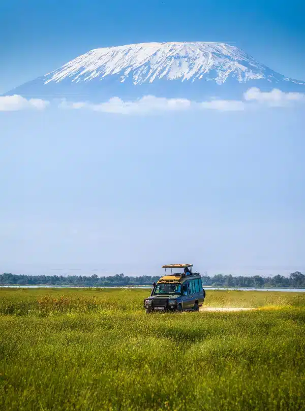 Safari vehicle on a game drive in Amboseli with Mount Kilimanjaro in the background – Sopa Lodges experience