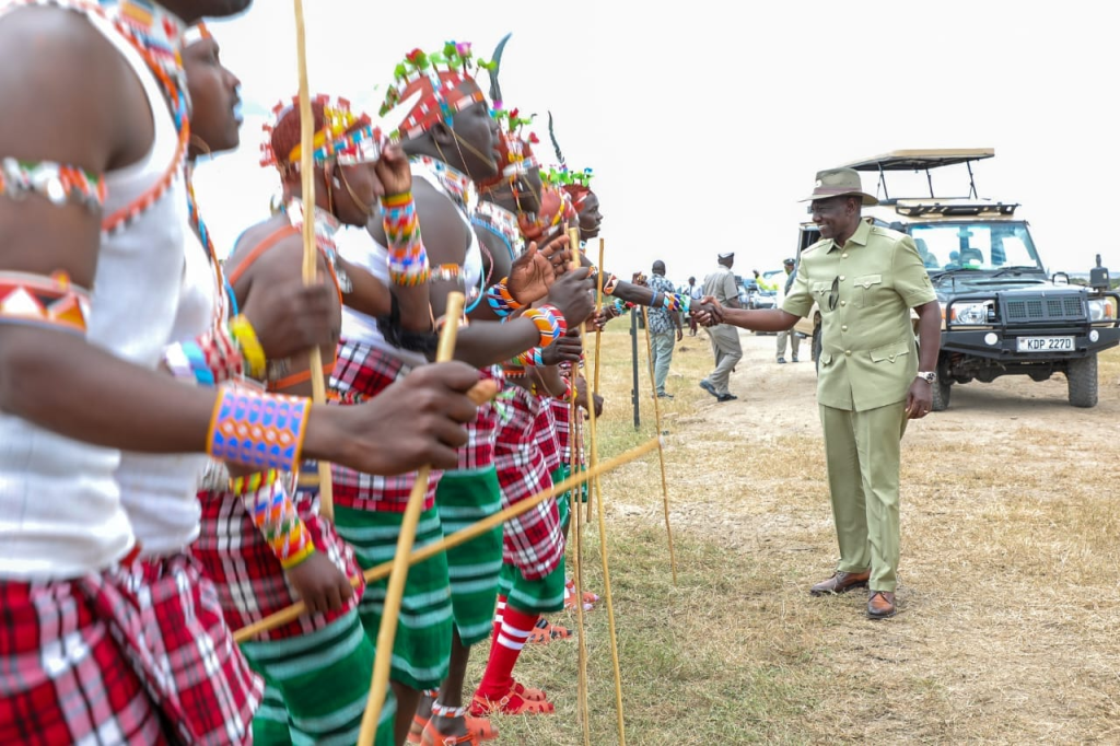 Kenyan leader interacting with Maasai dancers during a traditional cultural ceremony