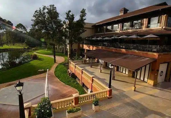 The Hub Karen Mall during the Nairobi Post-Safari Stopover, featuring outdoor restaurants, a lakefront walkway, and lush gardens.