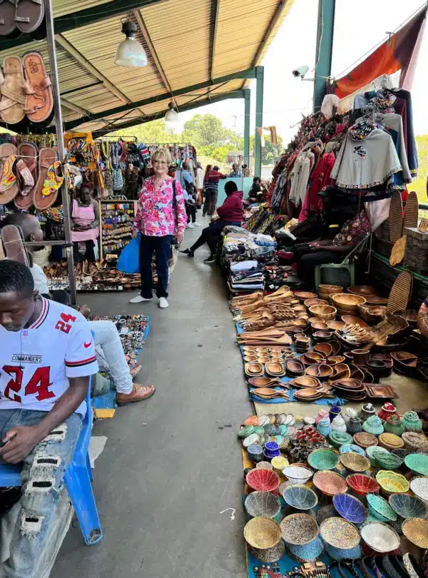 Traveler browsing colorful handmade crafts, beadwork, and wooden carvings at the Maasai Market in Nairobi, Kenya.