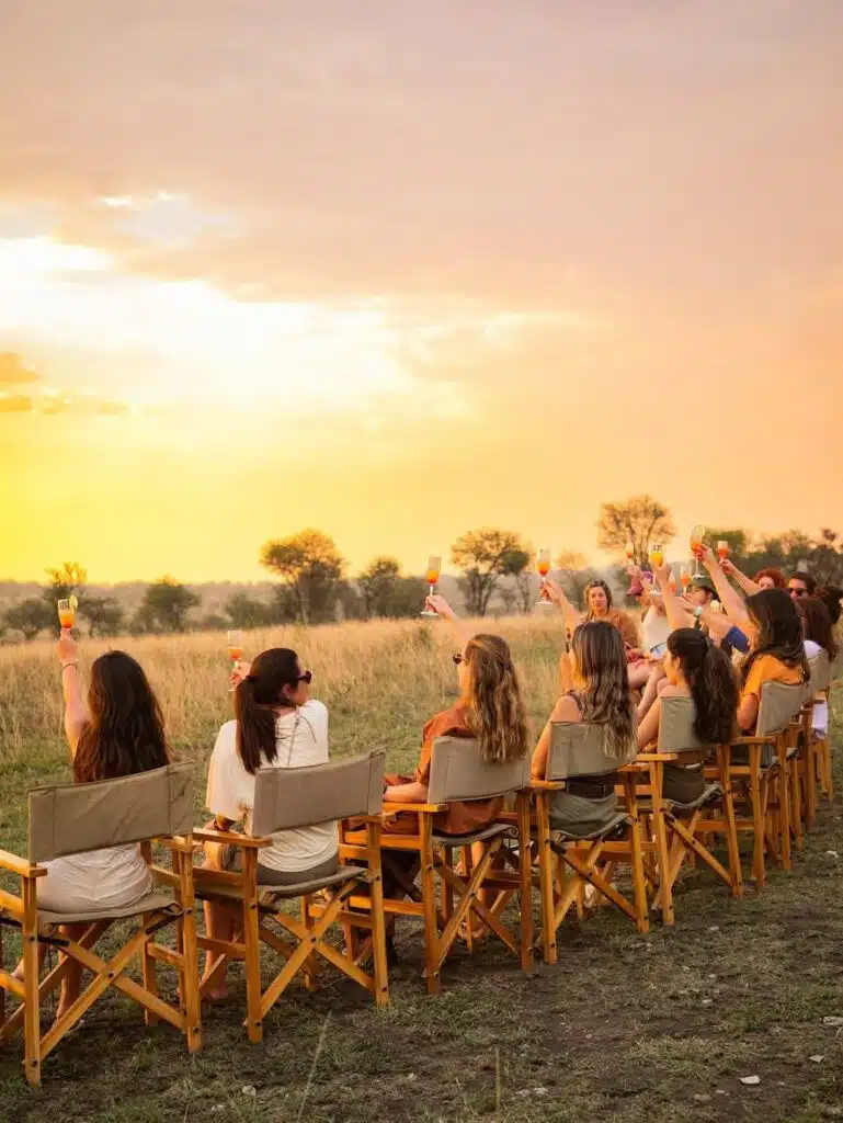 Guests enjoying a safari sundowner with drinks at sunset on a Kenya safari