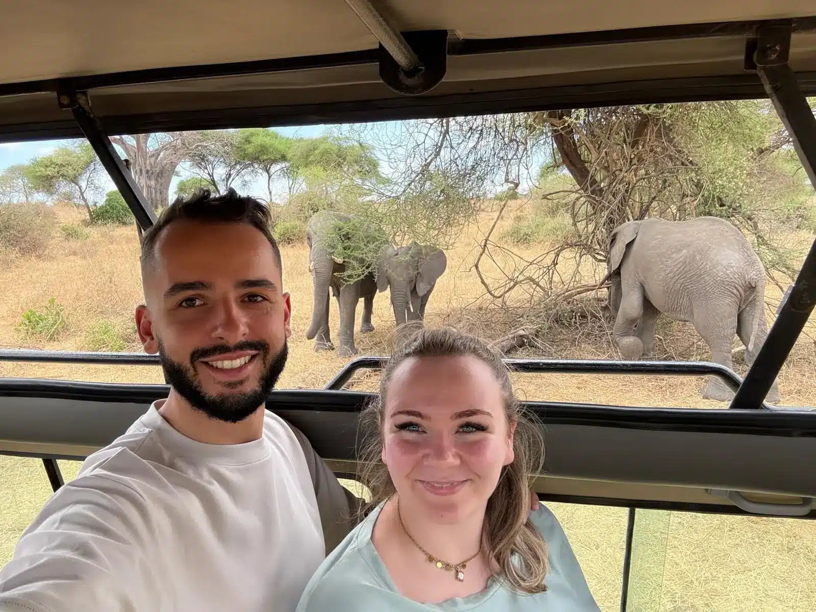 Couple enjoying close elephant sightings from a safari vehicle during a Serengeti game drive