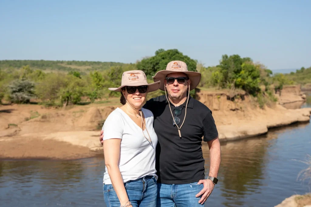 Travelers enjoying a private safari moment by the river in the Masai Mara.