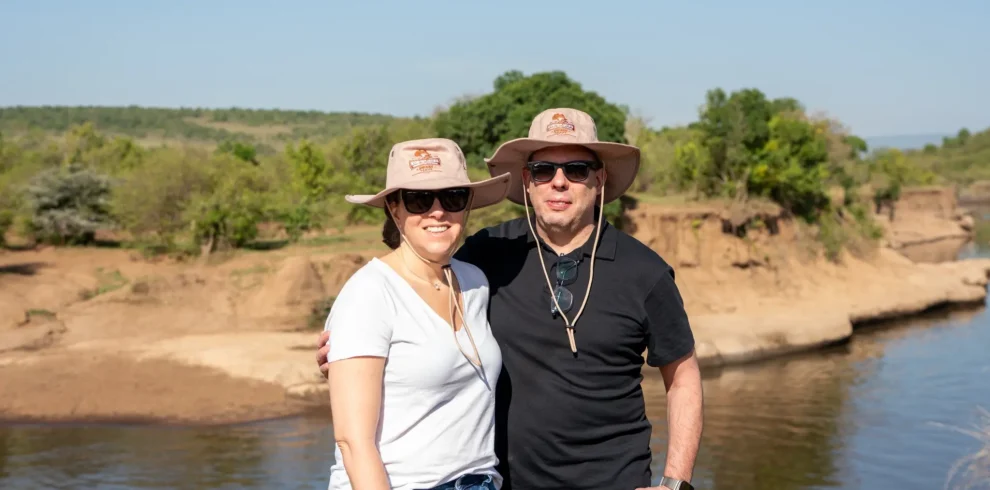 Travelers enjoying a private safari moment by the river in the Masai Mara.