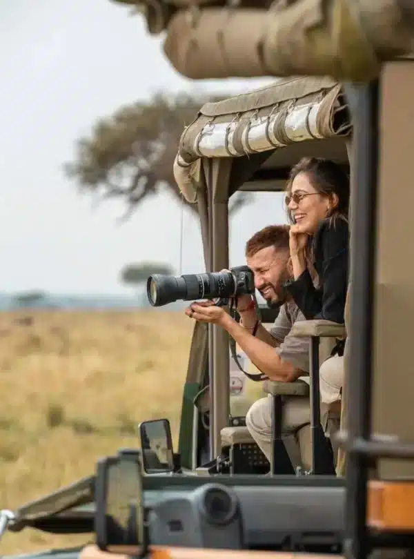 travellers photographing wildlife from an open safari vehicle on a 14-Day Kenya & Tanzania Safari
