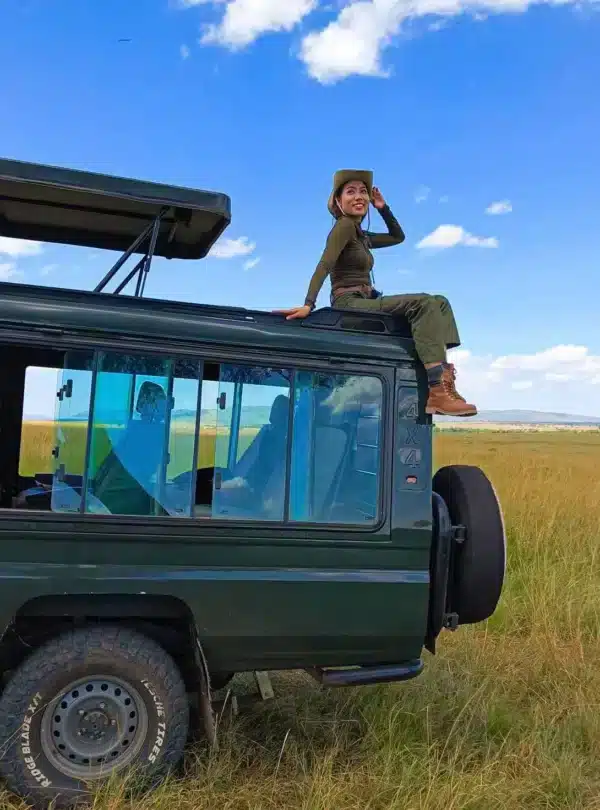 Guest on a safari Land Cruiser enjoying open savannah views on a private Kenya safari.