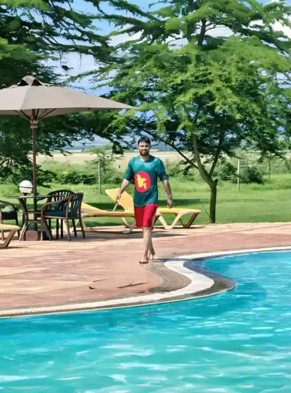 Guest enjoying the pool at Ol Tukai Lodge with views of the Amboseli plains