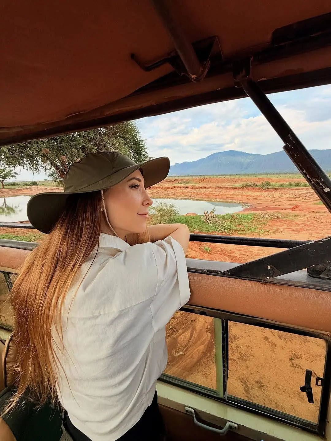 Traveler taking in landscape views from a safari vehicle on a 7-day Kenya safari