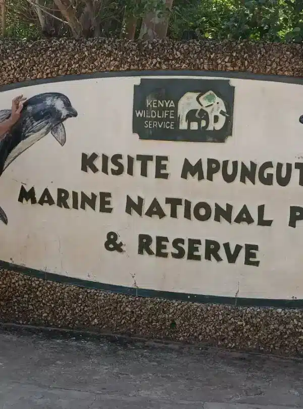 Visitors at the Kisite Mpunguti Marine Park entrance sign in southern Kenya, a common Coast add-on from Diani for marine safaris.